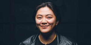 A photo of sound artist Ashley Au, smiling for the camera.